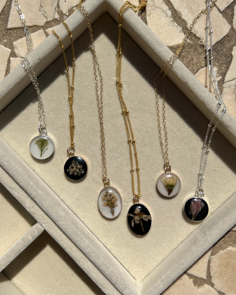 Gold filled pendant necklace in round and oval shapes featuring real preserved flowers, handcrafted by Happihome for an elegant floral keepsake.
